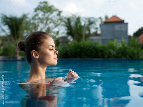 side view woman in pool in swimsuit transparent water portrait landscape
