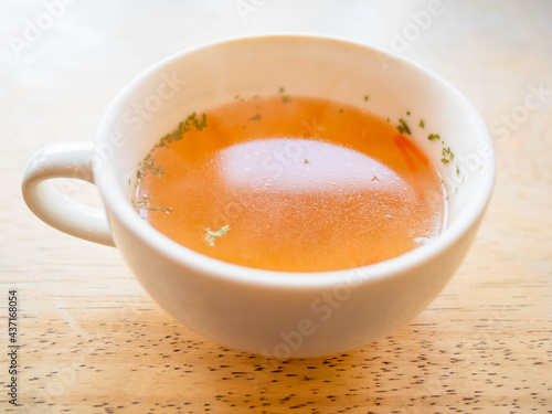 白いカップに入った透き通ったコンソメスープ