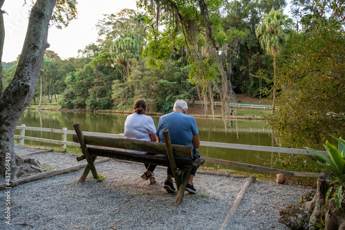 casal de idosos sentados no banco aproveitando a tarde no parque  photo