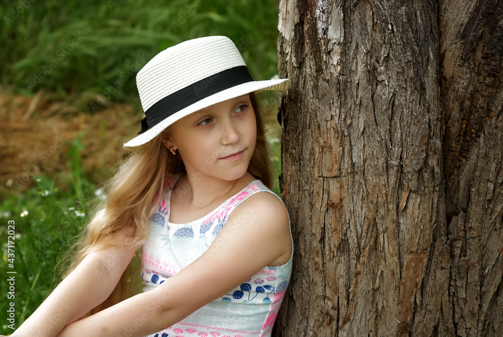 Portrait of a little girl in a hat on nature