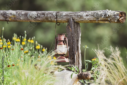 old rusty lantern hanging from hitching post