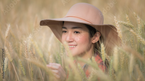 young asian girl in plaid shirt and hat checking barley rice portrait headshot with selective focus