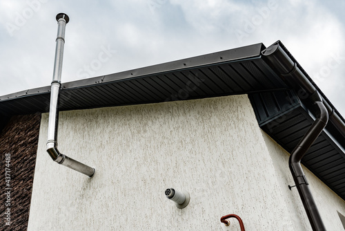 Central gas heating boiler flue chimney on house exterior.