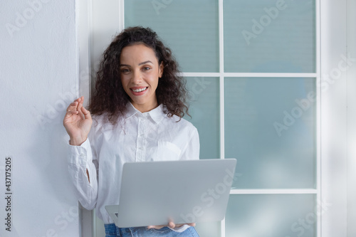 Cheerful beautiful businesswoman stand holding laptop and smile in workplace at office, successful woman, copy space.