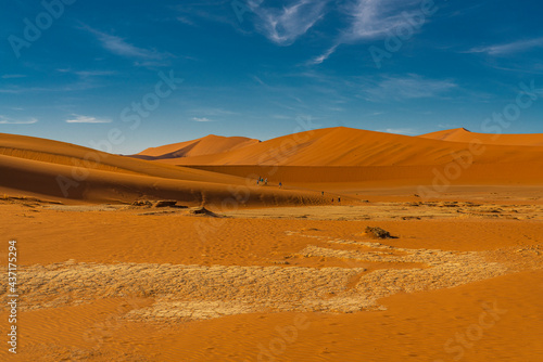 People at the way to Deadvlei, landscape with large orange sand dunes at Sossusvlei