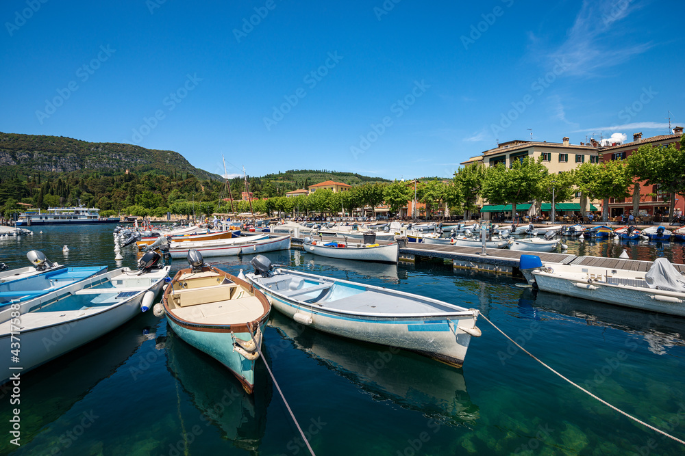 Small boats moored in the port of Garda town, tourist resort on the coast of Lake Garda (Lago di Garda). Verona province, Veneto, Italy, southern Europe.
