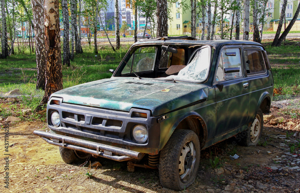 Abandoned green passenger SUV after a serious crash close-up. blurred focus Abandoned green passenger SUV after a serious crash close-up. blurred focus