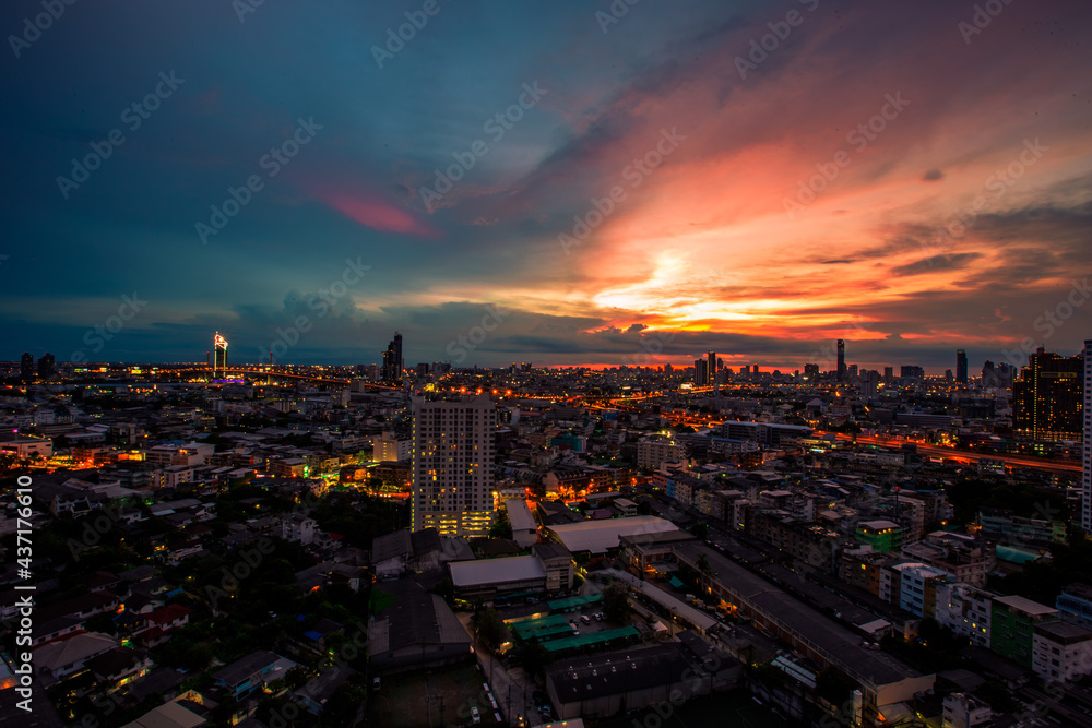 Fototapeta premium The high angle background of the city view with the secret light of the evening, blurring of night lights, showing the distribution of condominiums, dense homes in the capital community