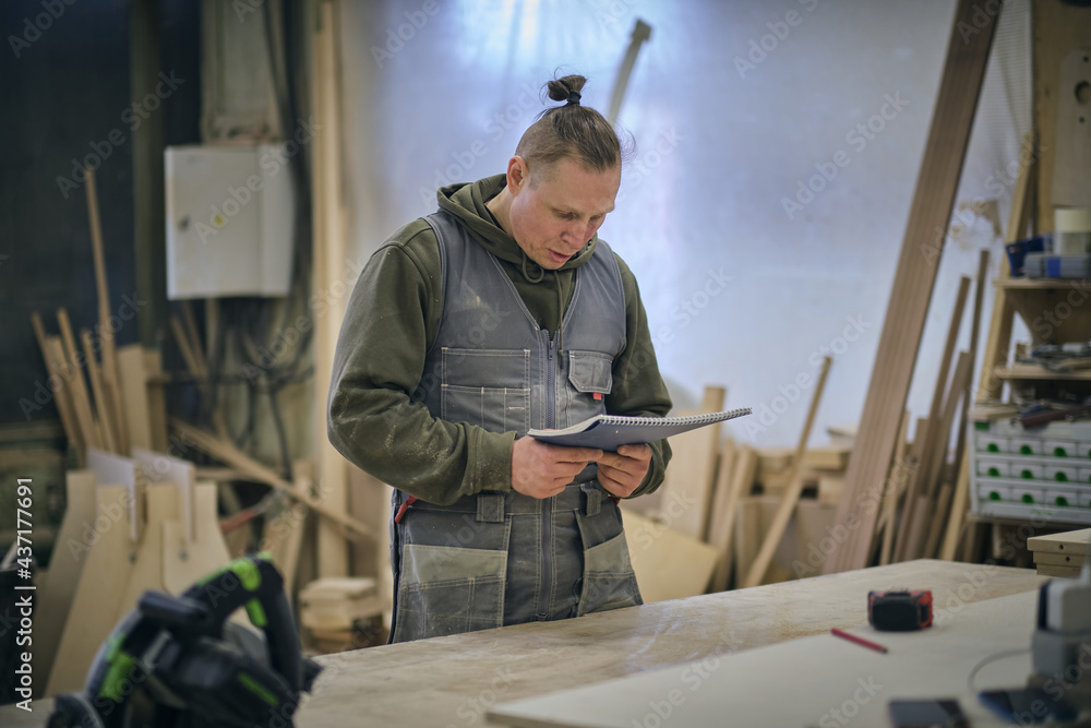 Woodwork and furniture making. Joinery, woodworking and furniture making, professional carpenter cutting wood in carpentry shop, industrial concept Woodwork and furniture making. Joinery, woodworking and furniture making, professional carpenter cutting wood in carpentry shop, industrial concept