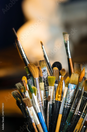 Set Collection Art Paint Brushes In Cup On Artist's Desktop. Artistic Equipment In Studio