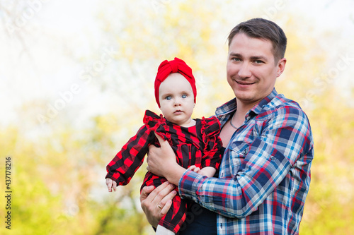 Man holding adorable toddler girl in his arms during a walk. Little girl having fun with her daddy outdoors. Fatherhood or father s day concept