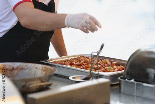 Chef in rubber gloves preparing food in restaurant closeup