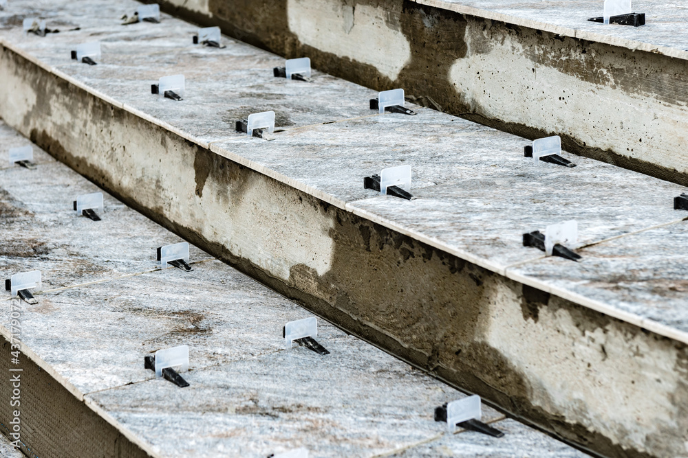Tile leveling system with plastic clips and wedges on the steps. Tile leveling system with plastic clips and wedges on the steps.