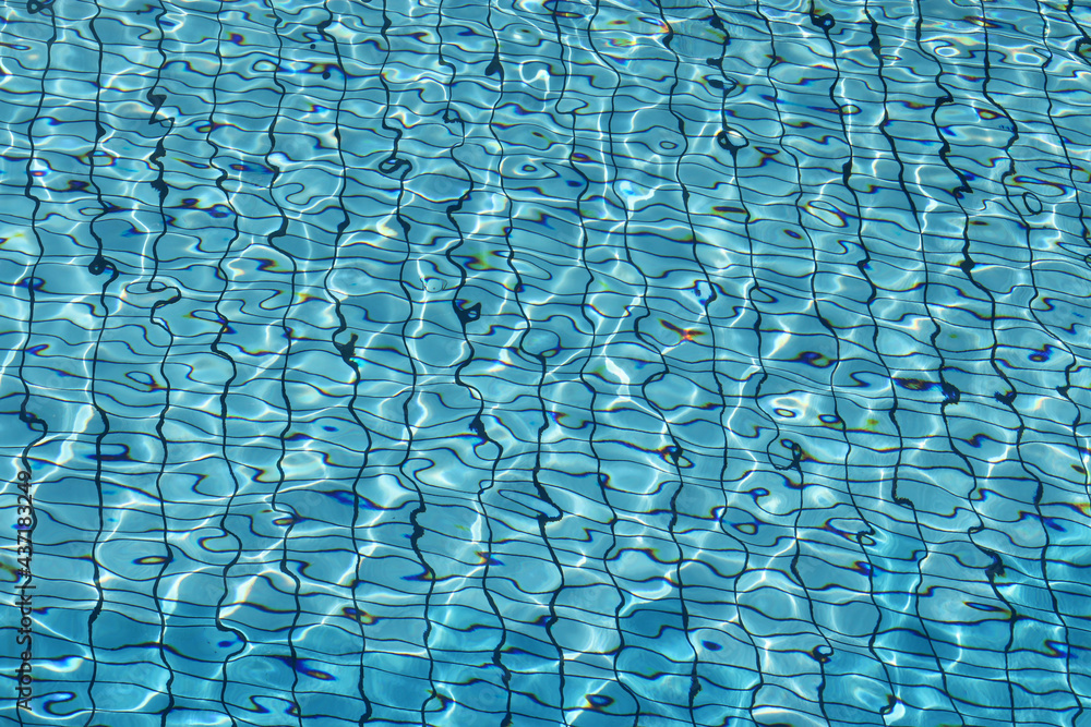 Fototapeta premium View through clean water to bottom of swimming pool lined with blue tiles