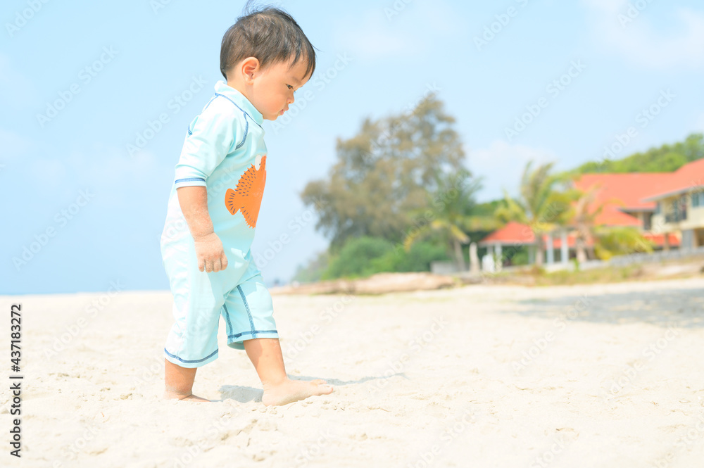 Kid playing with sand on the beach by the sea. holidays with children near the sea.