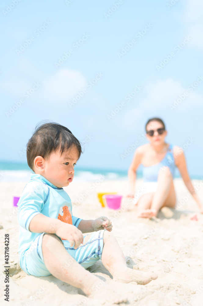 Happy family resting at beach in summer, Mother and baby feet at the sea foam at the sunlight water is moving Happy family resting at beach in summer, Mother and baby feet at the sea foam at the sunlight water is moving