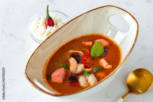 Asian Tom Yum soup in bowl on gray table