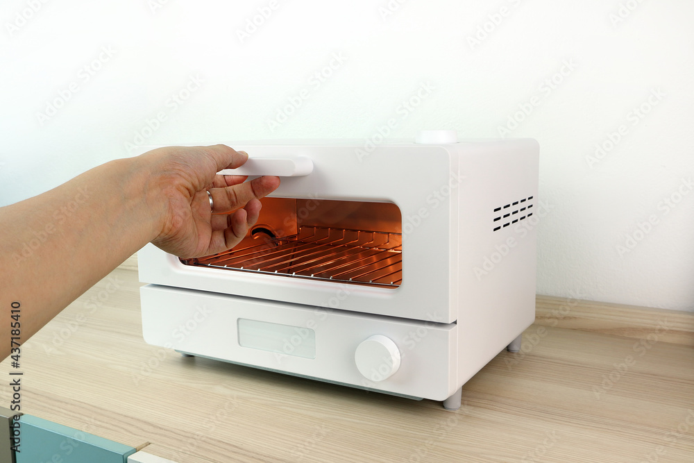 white modern design toaster oven is on the wooden table with white cement  wall background in