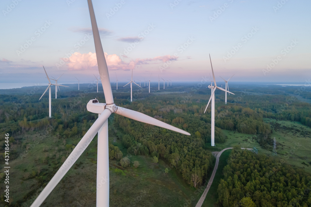 Wind turbines on sunset at summer evening. Renewable energy