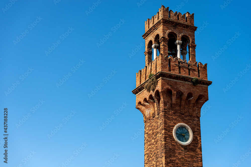 Close-up of the ancient Civic Tower or Clock Tower in Murano island in medieval style. Campo Santo Stefano (Saint Stephen square), Venice, UNESCO world heritage site, Veneto, Italy, Europe. 
