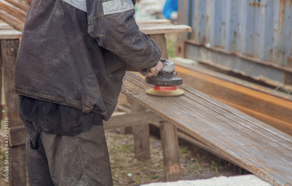 A worker grinds metal at a construction site.