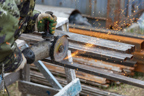 A worker cuts metal at a construction site. photo