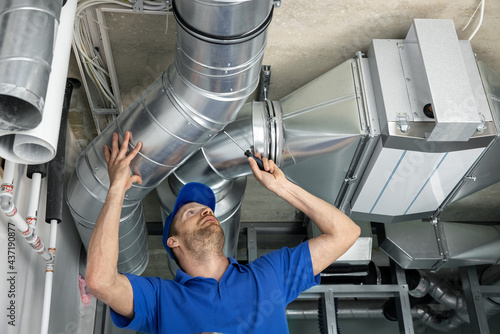 Fotografia hvac services - worker install ducted pipe system for ventilation and air condit