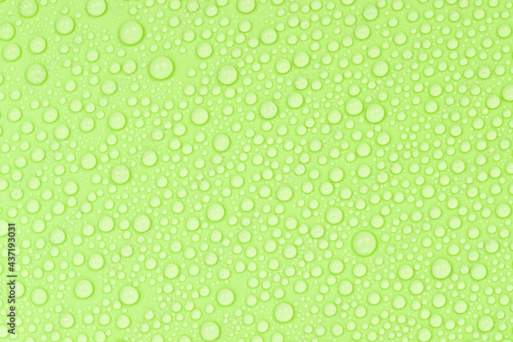 Water drops on green background texture. Backdrop glass covered with drops of water. green bubbles in water.