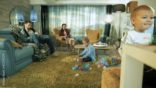 A happy young family. Dad and mom play with their sons in their apartment.