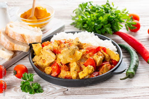 Indian chicken curry or kadai chicken with rice in a frying pan on a table