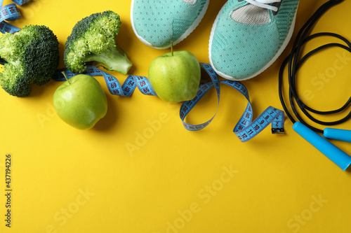 Healthy lifestyle accessories on yellow background, space for text