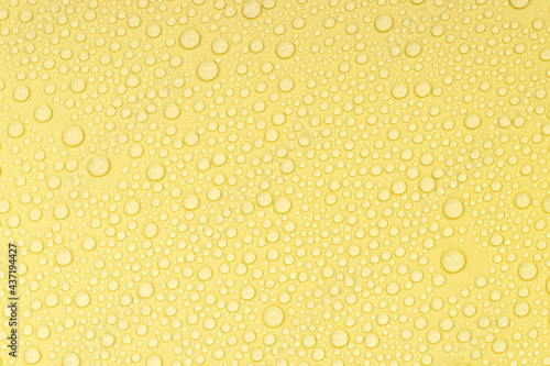 Water drops on yellow background texture. Backdrop glass covered with drops of water. yellow bubbles in water. beer texture