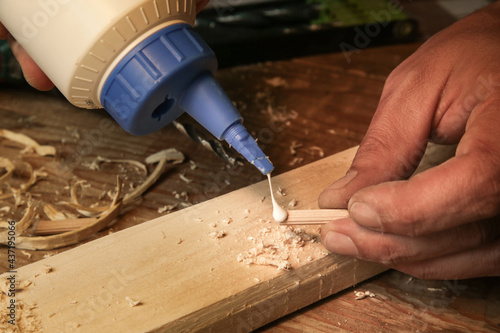Handyman assembling wooden pieces with a glue