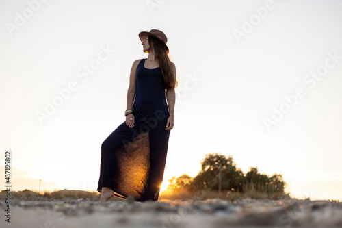 Woman posing at sunset near a beach photo