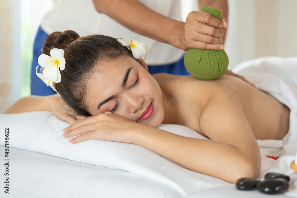 Beautiful Asian woman getting massage with thai herbal balls in spa salon,  enjoying and relaxing time Stock Photo | Adobe Stock
