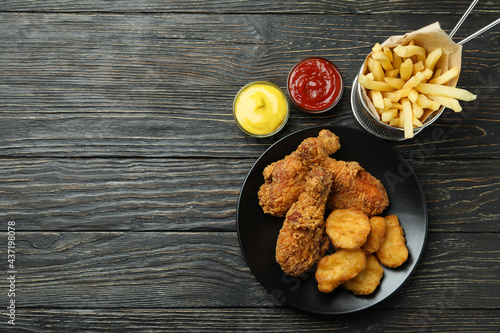 Concept of tasty eating with fried chicken on wooden background