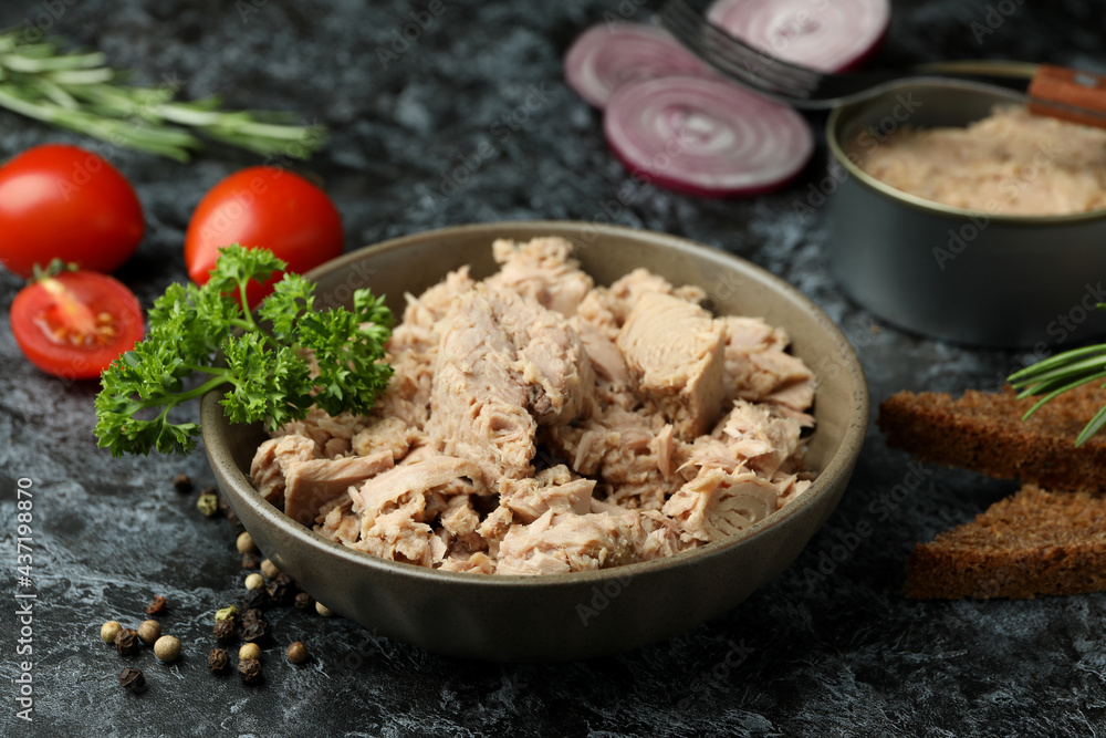 Concept of tasty eating with canned tuna on black smokey background Concept of tasty eating with canned tuna on black smokey background