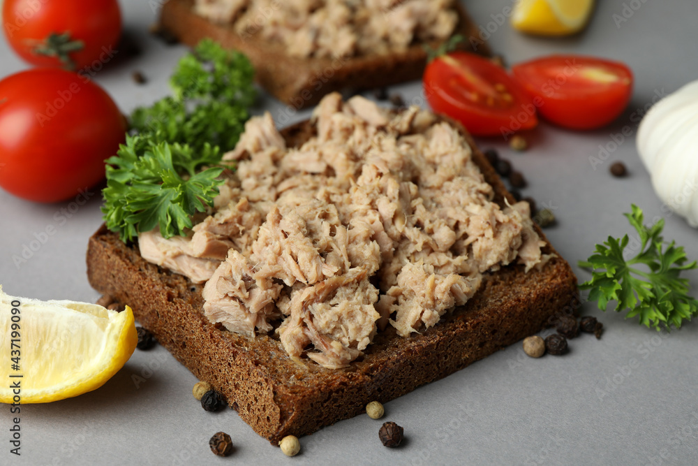 Sandwiches with canned tuna and ingredients on gray background Sandwiches with canned tuna and ingredients on gray background
