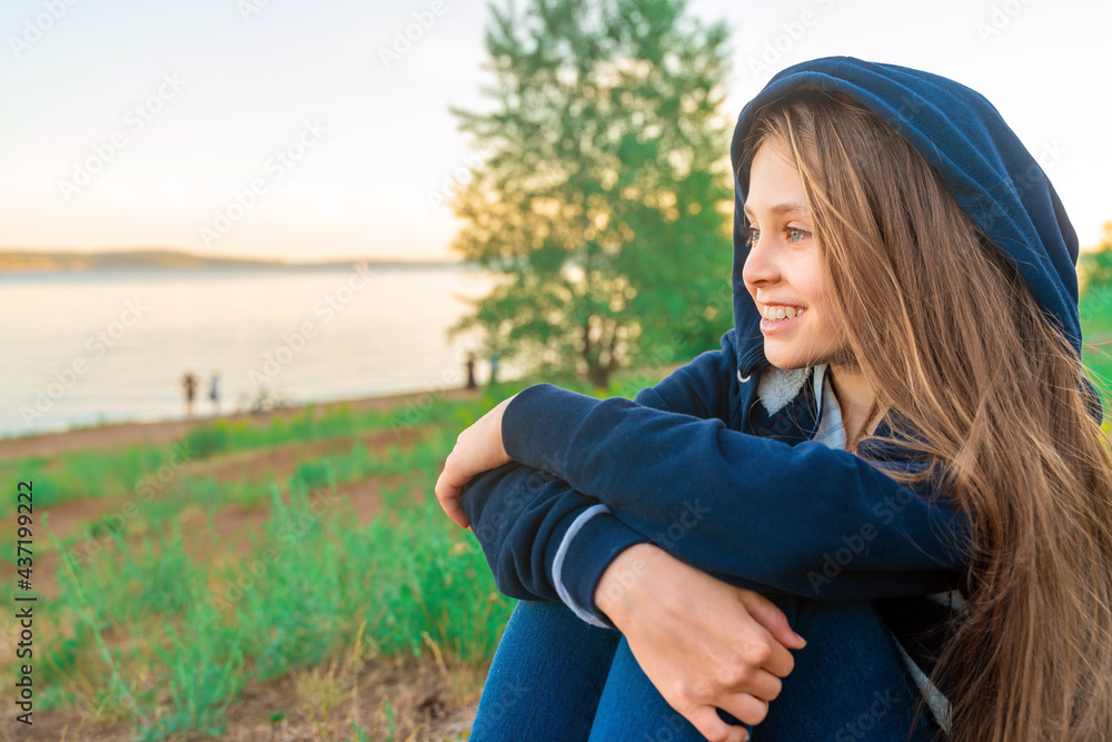 Portrait of a happy little teenage girl in a hood at sunset, the concept of mental health care Portrait of a happy little teenage girl in a hood at sunset, the concept of mental health care