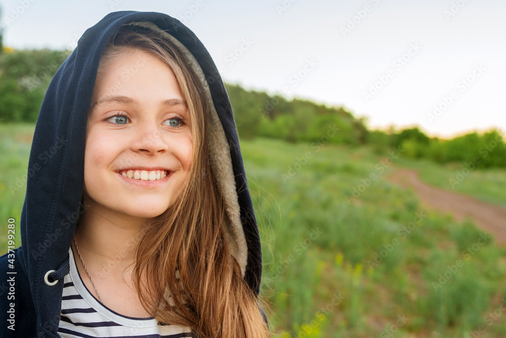 Portrait of a happy little teenage girl in a hood at sunset, the concept of mental health care Portrait of a happy little teenage girl in a hood at sunset, the concept of mental health care