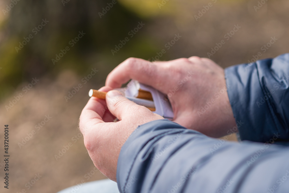 closeup person's hand pick a cigarette from the carton cigarettes pack box closeup person's hand pick a cigarette from the carton cigarettes pack box