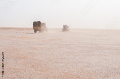 Off-road vehicle in a sandstorm / Off-road vehicle drive in the sandstorm, Sahara, on the Lac Iriki, Morocco, Africa. photo