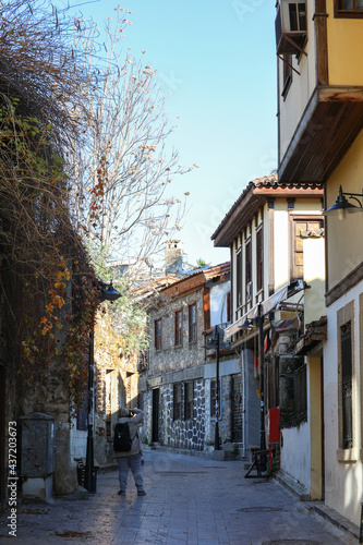Tourists visiting the ancient city of Kaleici take pictures of traditional old buildings and old carpet makers.