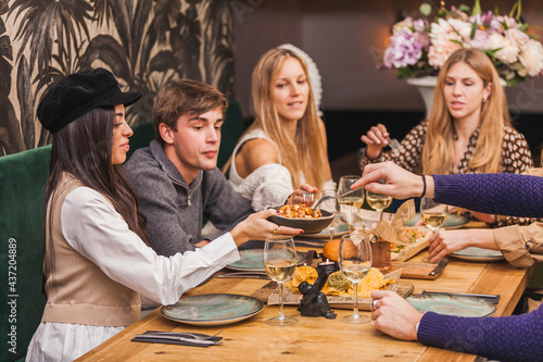 Group of friends at a dinner party eating spicy potatoes