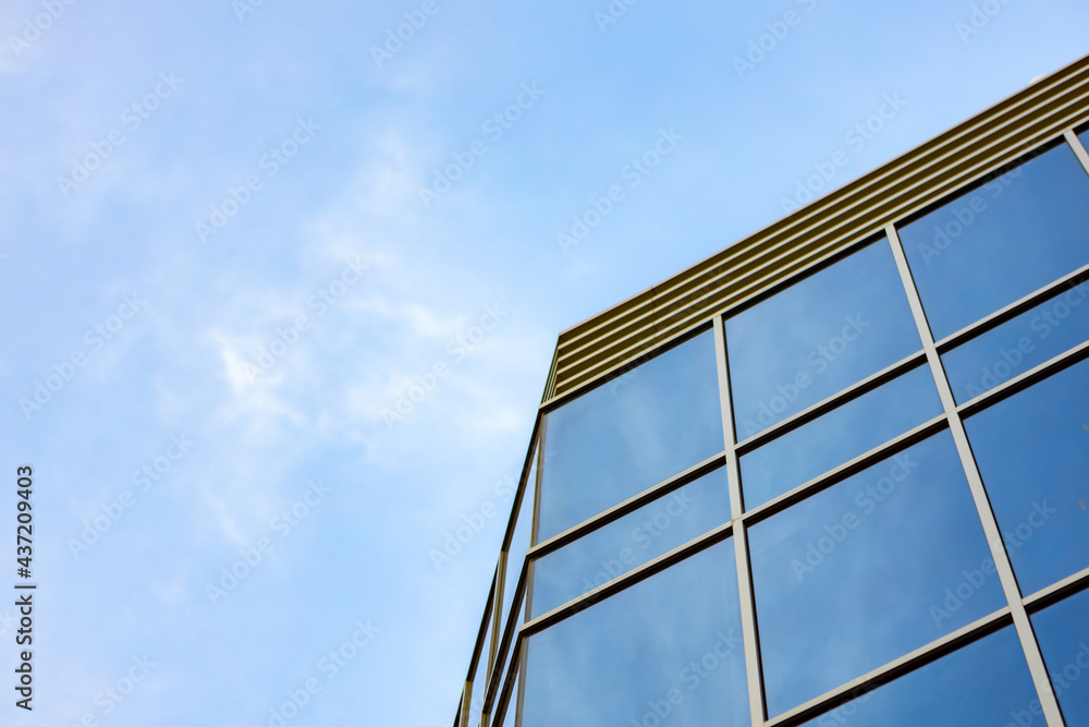 Glass skyscraper against blue sky, view from bottom Glass skyscraper against blue sky, view from bottom