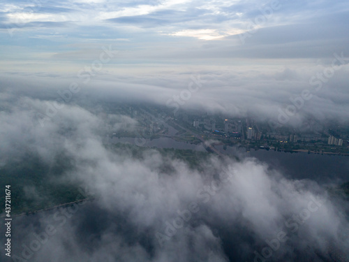 High view of the Dnieper River in Kiev. Aerial high flight above the clouds.