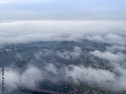 High view of the Dnieper River in Kiev. Aerial high flight above the clouds. © Sergey