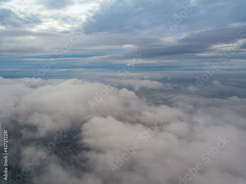 Aerial high flight above the clouds. The rays of the rising sun break through the clouds.