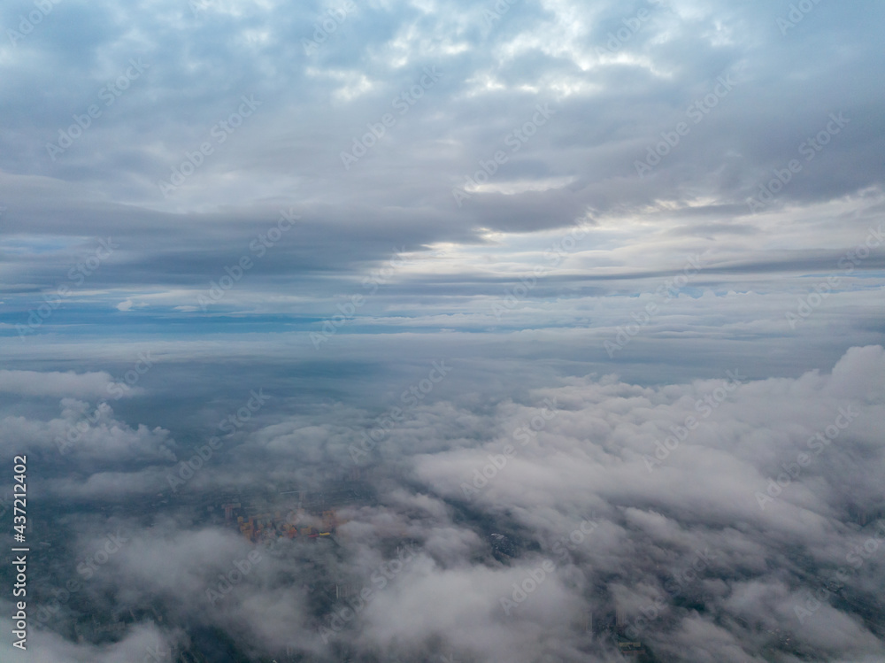 City under the clouds at dawn. Aerial high drone view. City under the clouds at dawn. Aerial high drone view.