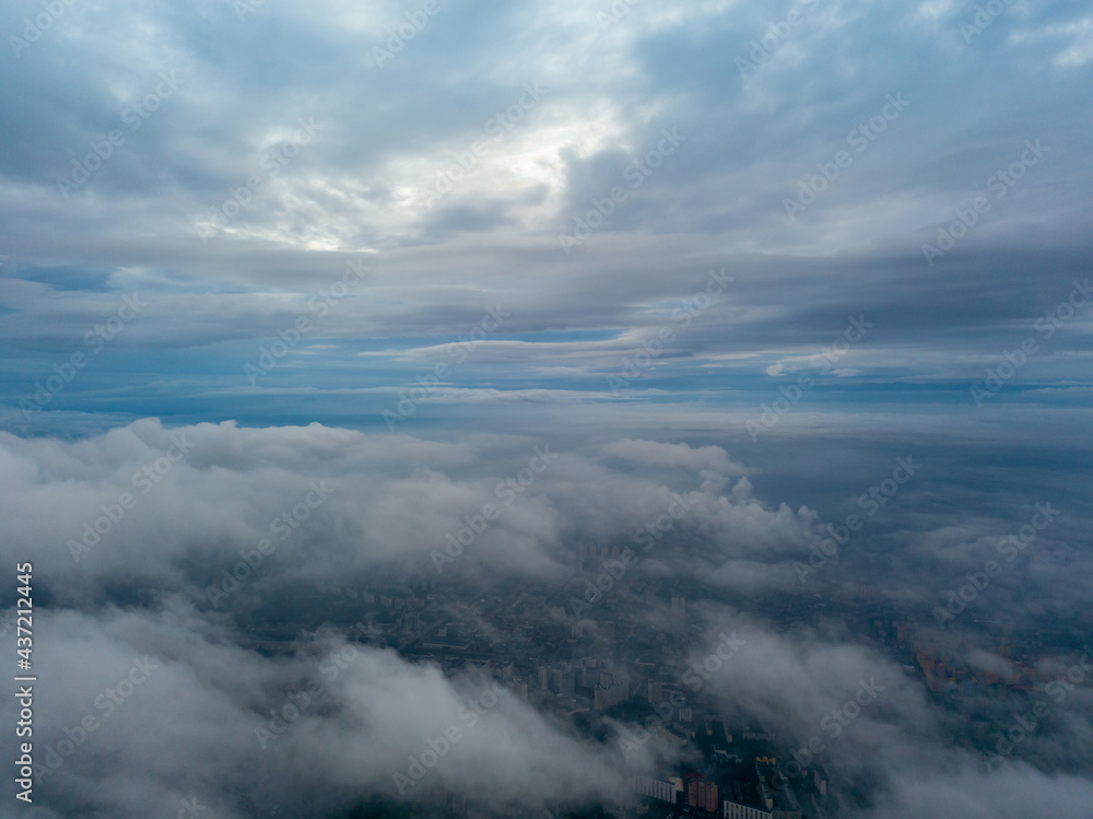 City under the clouds at dawn. Aerial high drone view.